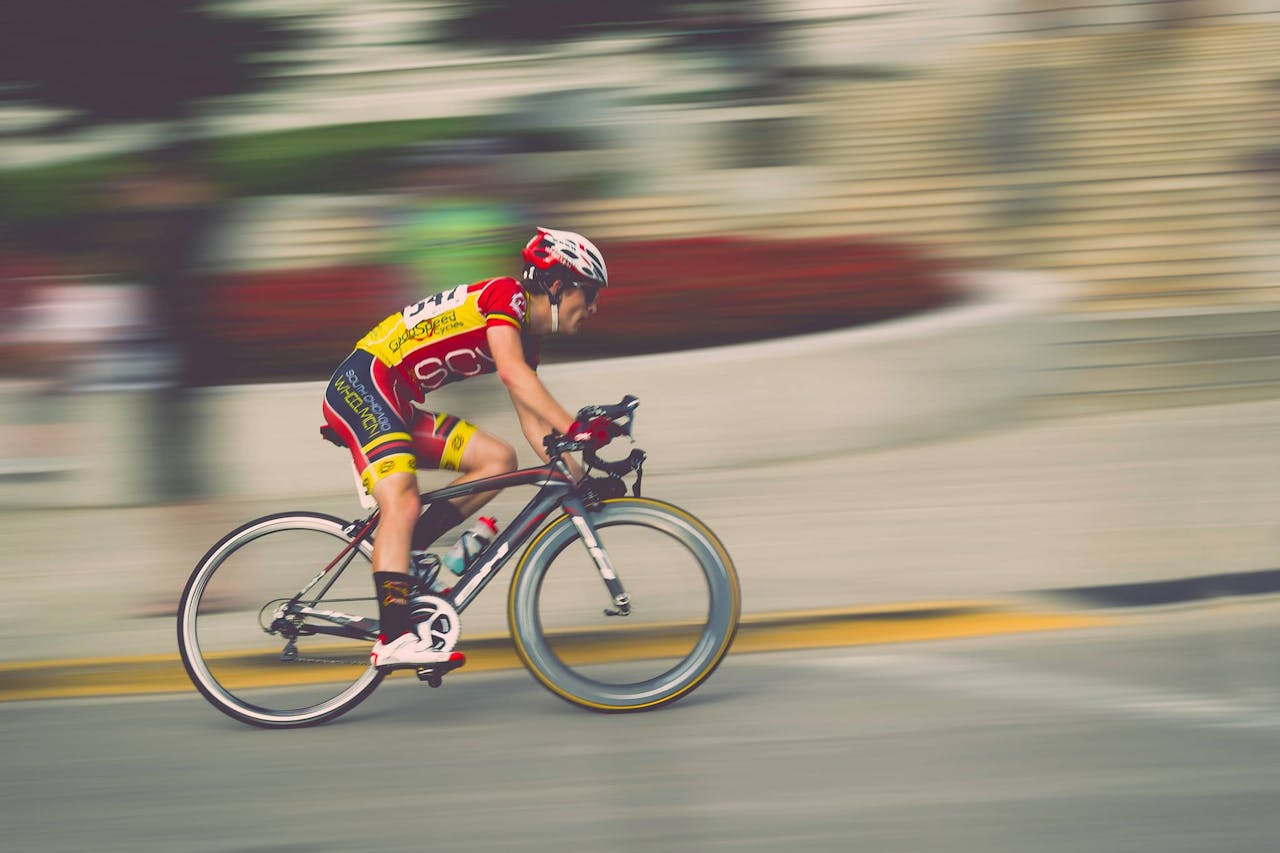 A cyclist in motion during a fast-paced race, highlighting speed and athleticism.